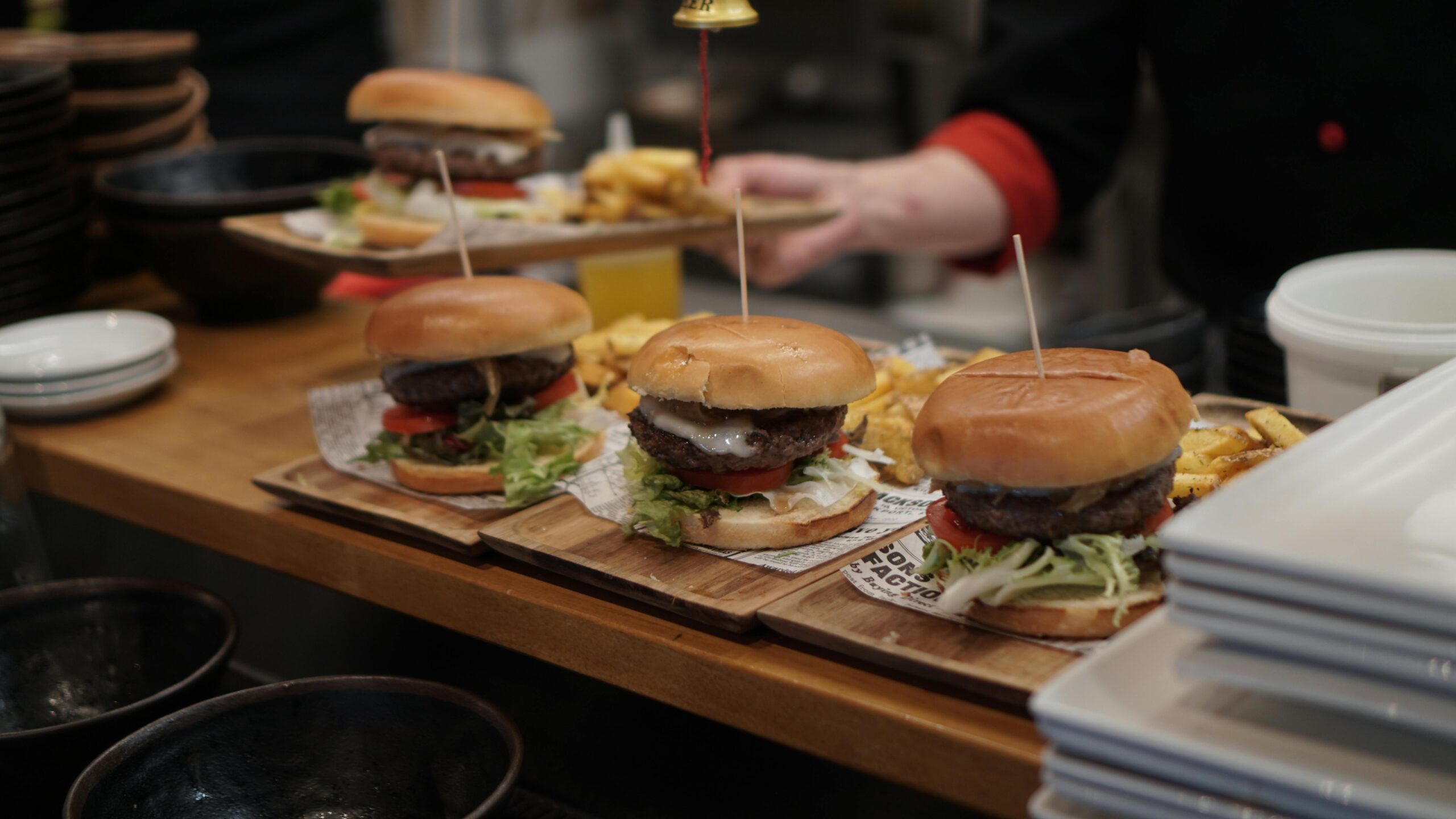 Juicy gourmet burgers with fries ready to serve in a cozy restaurant setting.